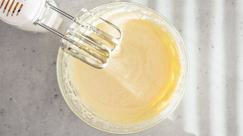 Overhead shot of cake batter in a bowl with a hand-held mixer