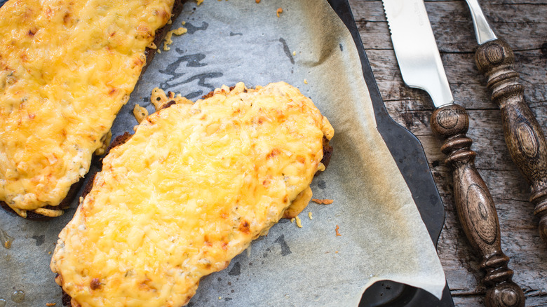 Two slices of Welsh rarebit on parchment