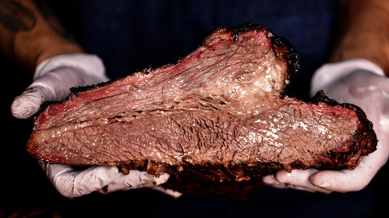 hands holding beef brisket
