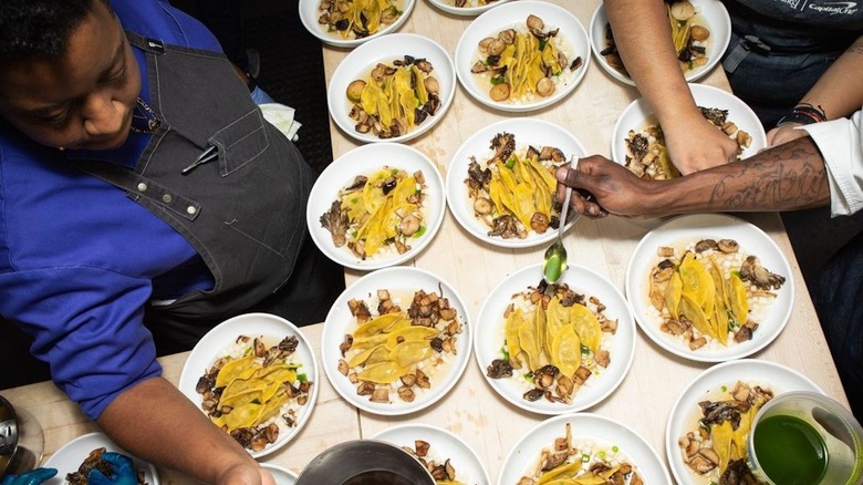 Chefs preparing plates of dumplings