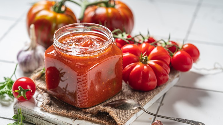 Homemade canned salsa in clear jar with tomatoes and garlic