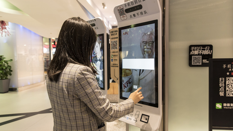 Person ordering at fast food kiosk