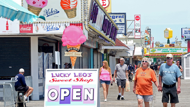 People walking near a sweet shop on a Jersey Shore boardwalk