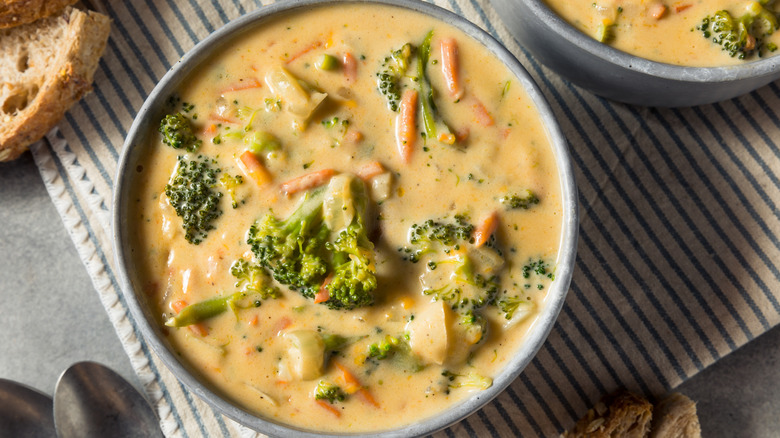 overhead shot of broccoli cheddar soup with carrots, potatoes, and paprika