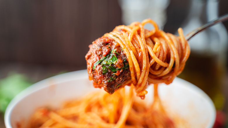 A forkful of pasta and sauce over a bowl