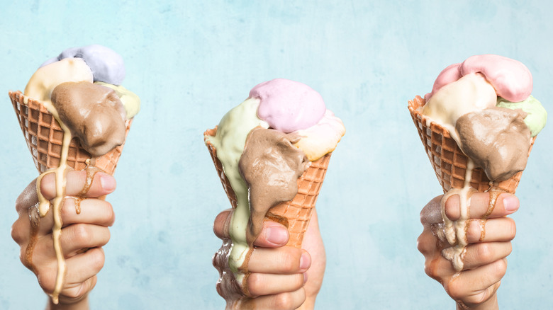hands holding melted ice cream cones