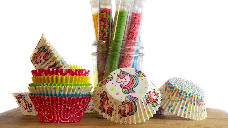 Cupcake liners next to mason jar with sprinkles
