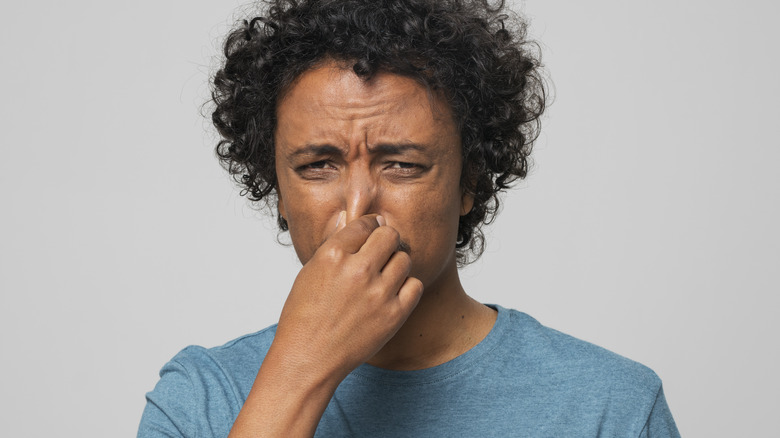 Person holding nose 