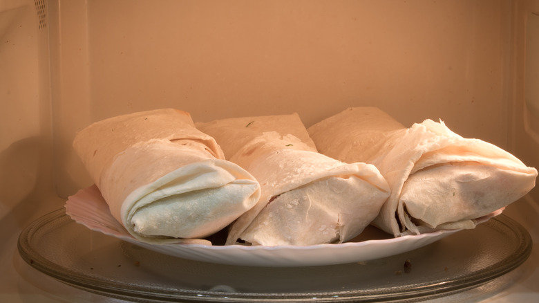 three frozen burritos in microwave