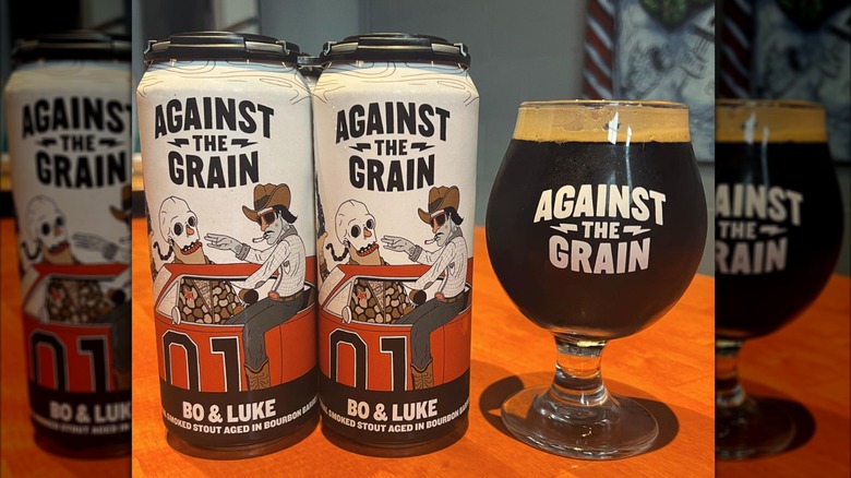 two cans and one glass of Against the Grain stout beer