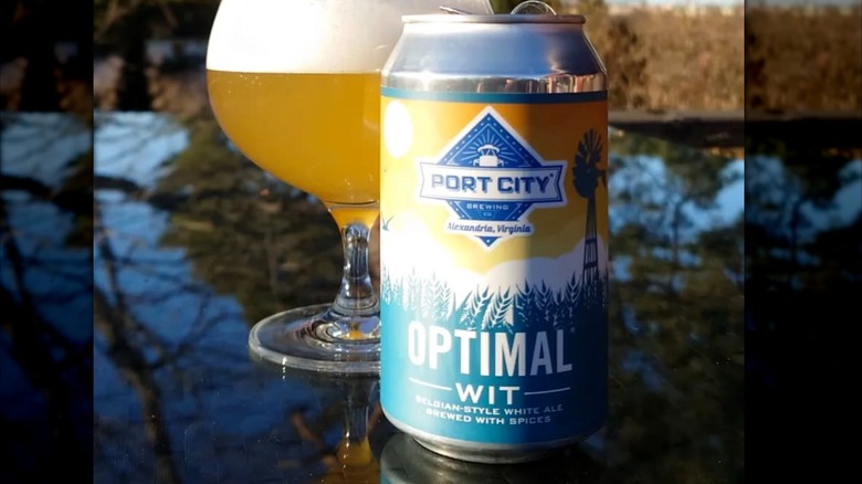 can and glass of optimal wit beer on outside table