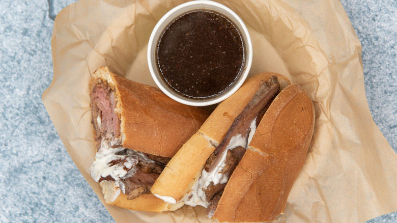 French dip sandwich with au jus in a basket