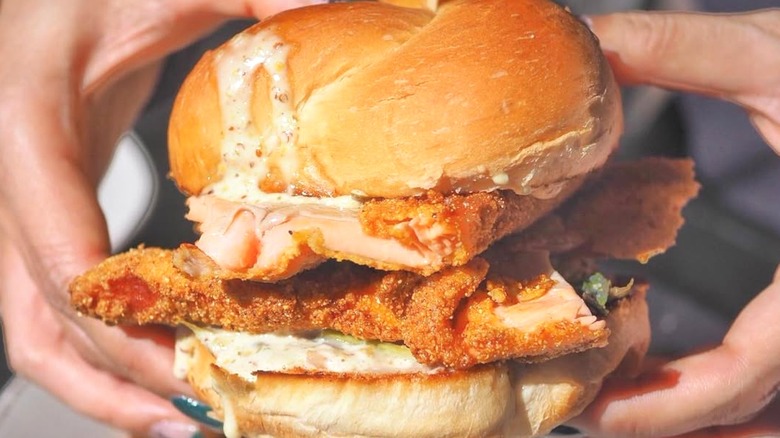 Person holding trout sandwich