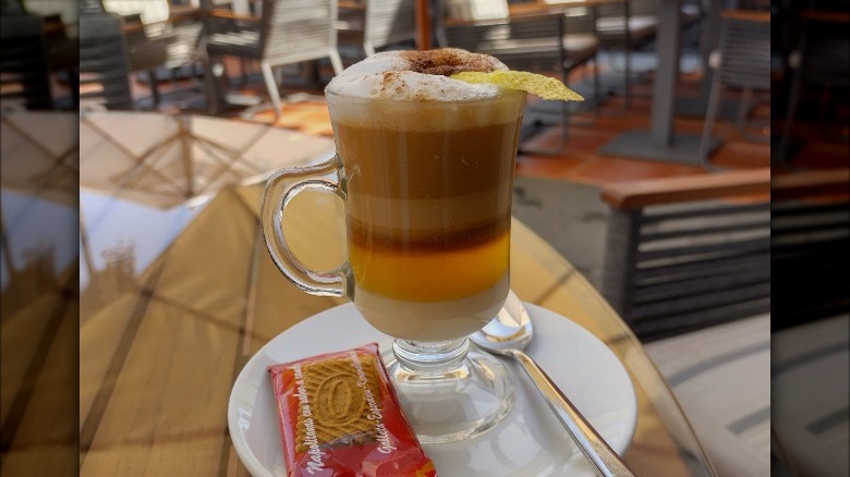 Barraquito coffee drink on plate with cookie