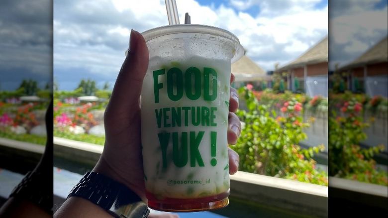 Man holding cup of cendol 