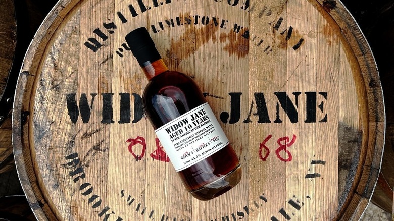 bottle of bourbon laying on barrel