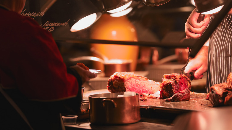 Chef cutting meat at buffet