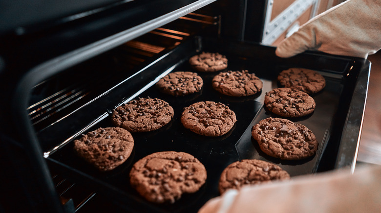 Cookies on a sheet being removed from oven