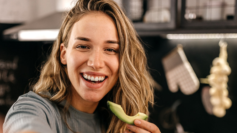 Woman eating avocado