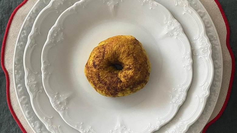 One bagel on four plates