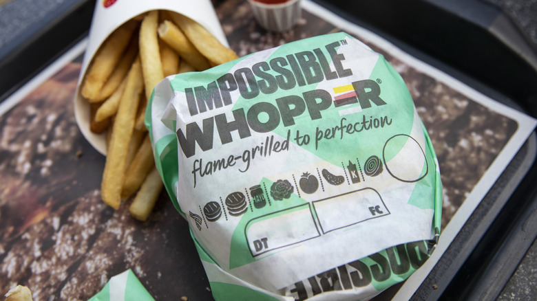 The Impossible Whopper on a tray along with a pack of fries.