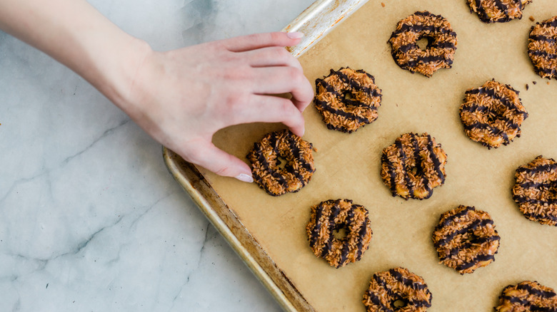 Person reaching for a tray of girl scout cookies