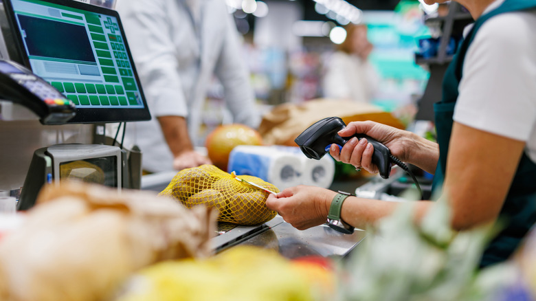 Supermarket cashier working, scanning an item
