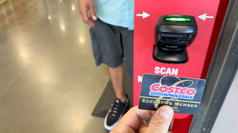 Person scanning Costco membership card at entry