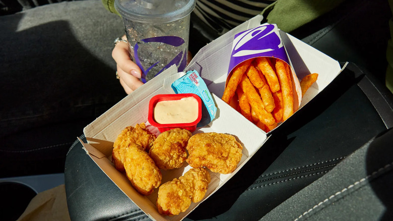 Taco Bell chicken nuggets in an open box with Fire Ranch sauce and Nacho Fries