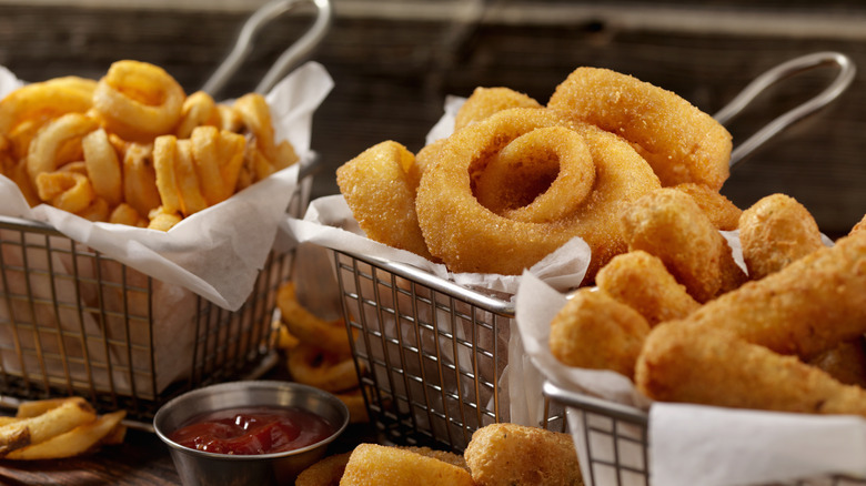baskets of curly fries, onion rings and mozzarella sticks