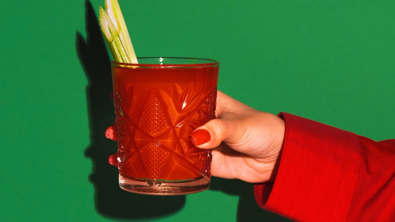 Hand holding Bloody Mary glass