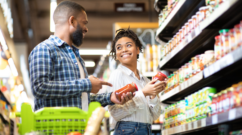 a man and woman choosing items in a grocery store
