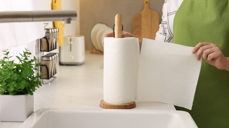 person ripping a sheet of paper towel