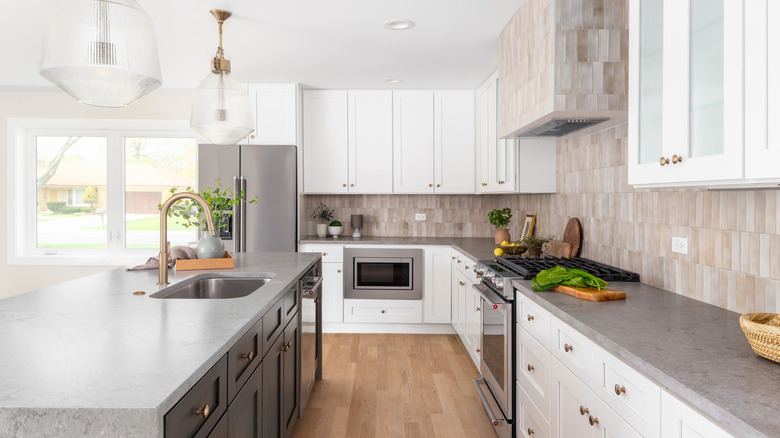 A beautiful, light-filled modern kitchen with a sink in the island