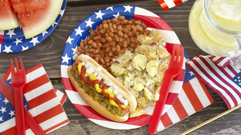 American flag paper plate with hot dog, baked beans, and potato salad