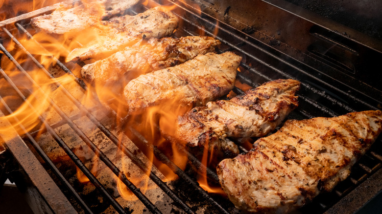 chicken on grill flames
