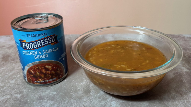 Chicken and sausage gumbo in bowl next to can