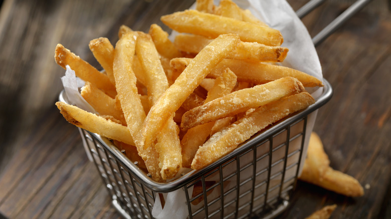 crispy golden French fries in a small serving basket