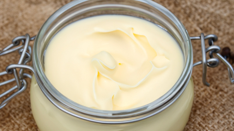 Closeup of a glass jar filled with homemade beef tallow, off-white in color