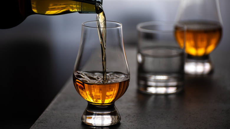 pouring whiskey into tulip glass