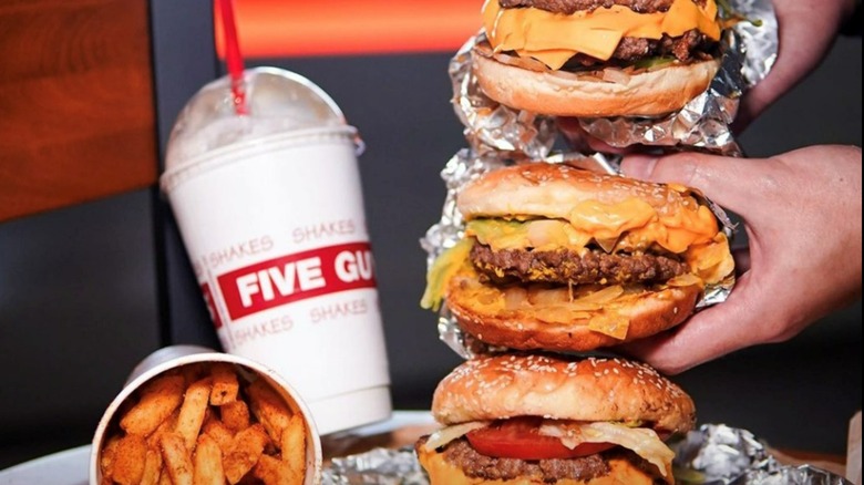 People holding Five Guy's burgers