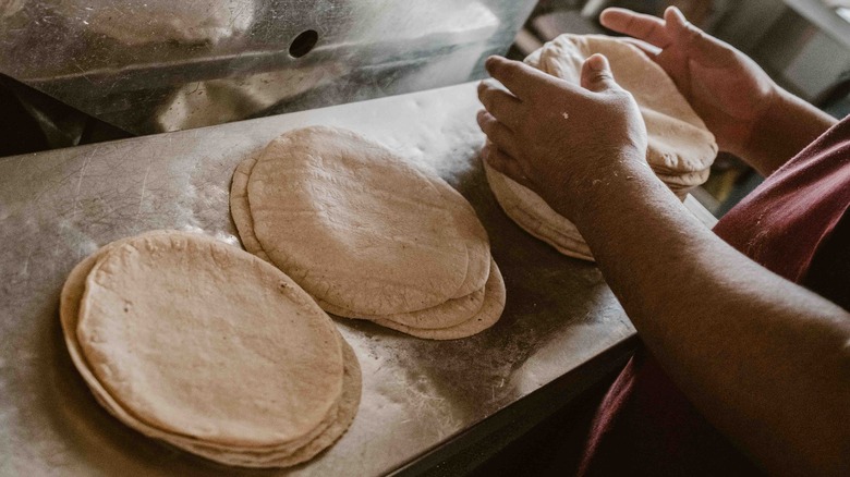 person stacking tortillas