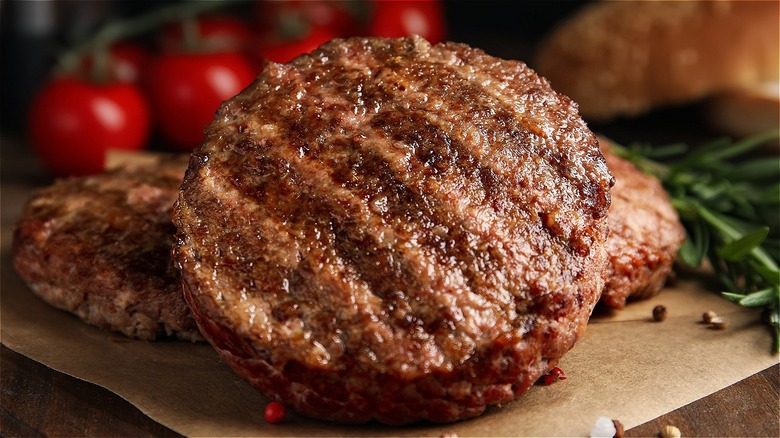 grilled burgers with tomatoes out of focus
