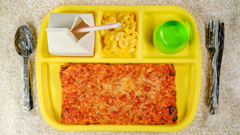 Pizza, mac and cheese, jellow, and a carton of milk on tray