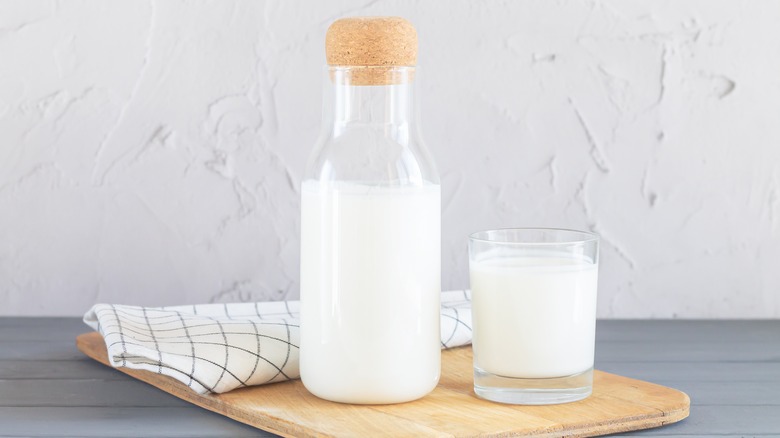 Bottle of buttermilk and glass on a serving board
