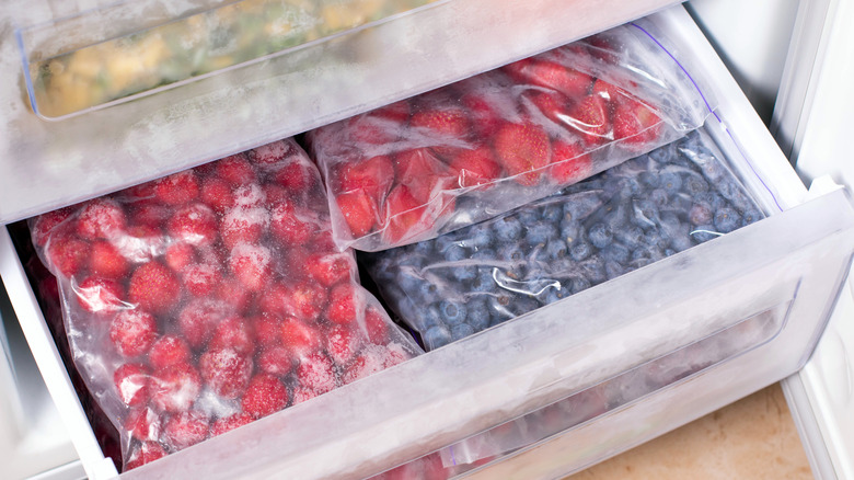 Freezer draw filled with bags of frozen berries