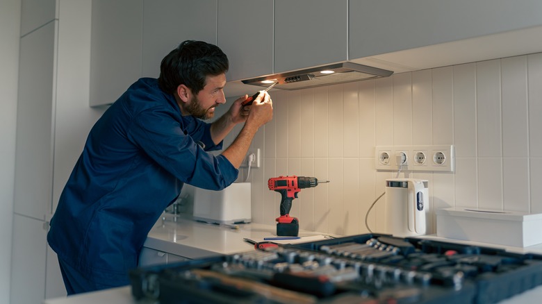 Worker fixing exhaust fan