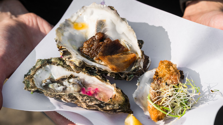 Raw, smoked, and fried oysters on a square plate