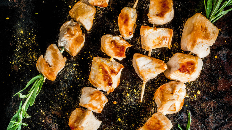 chicken rosemary skewers on black background