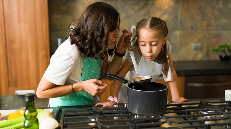 Mother and daughter blowing on food 